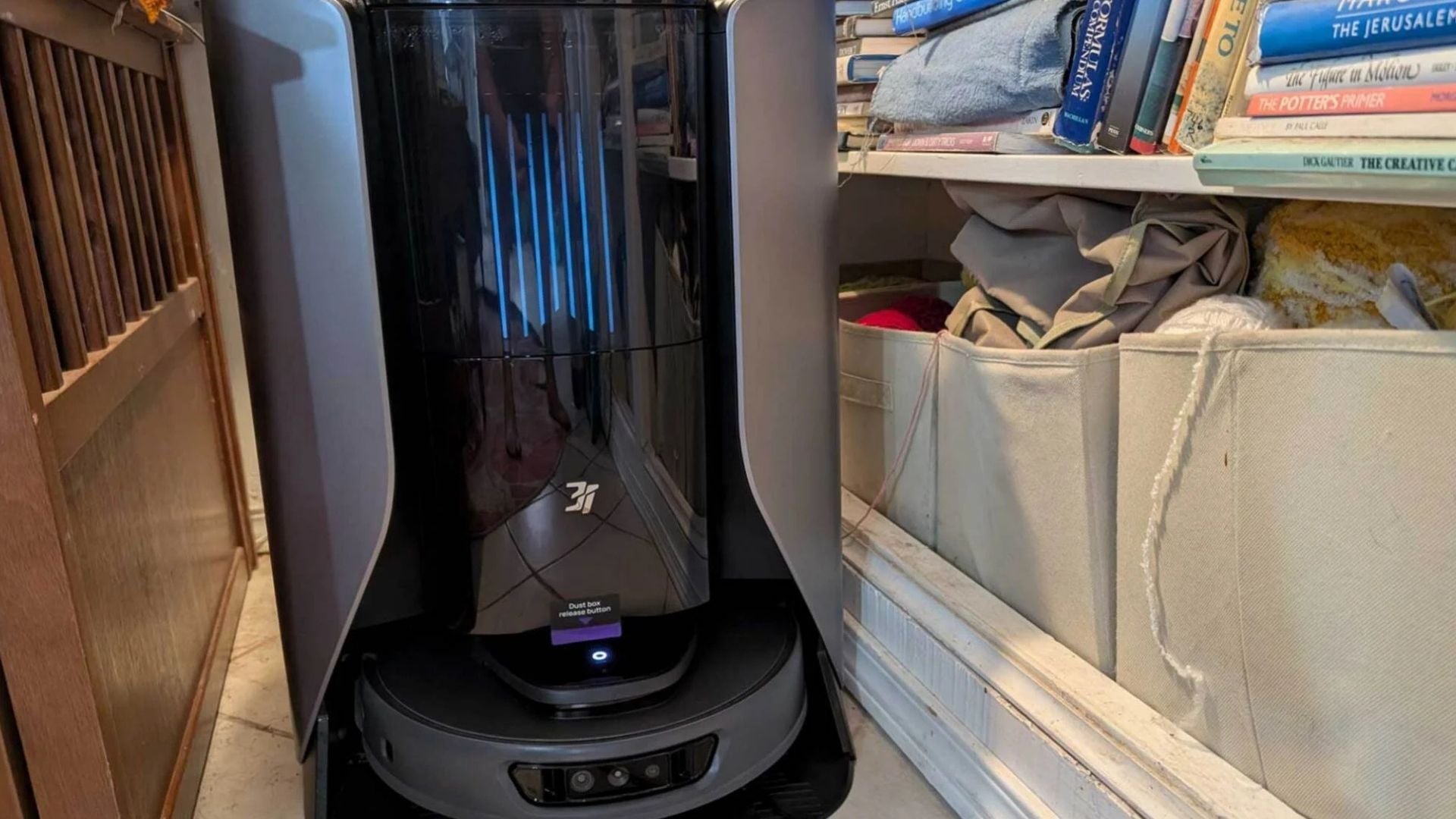 The robot vacuum cleaner is cleaning the corner of the closet.