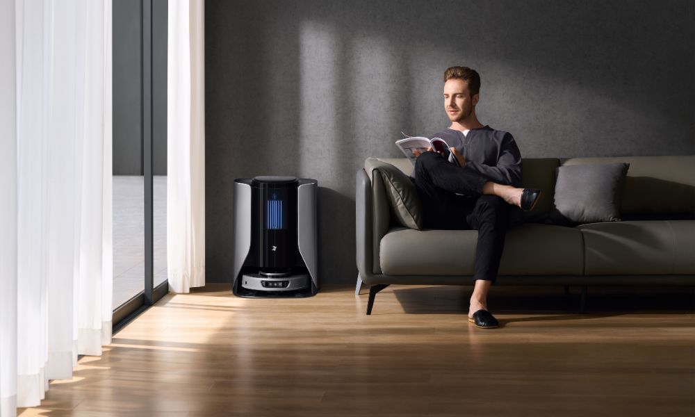 Man places the robot vacuum cleaner in the living room